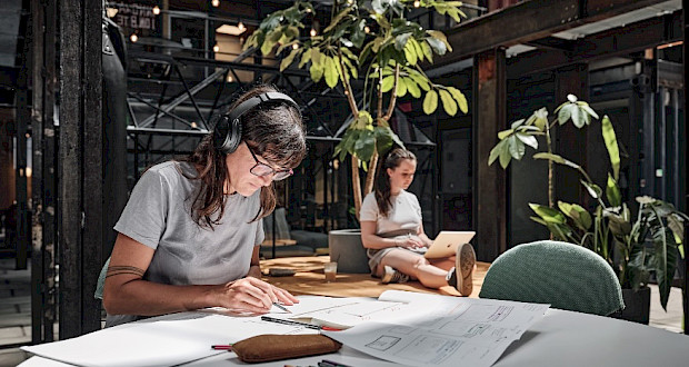 Coworkers working with headphones at Grünhof Kreativpark Lokhalle location