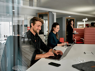 Coworkers work in a stylish space at Grünhof Freiburg