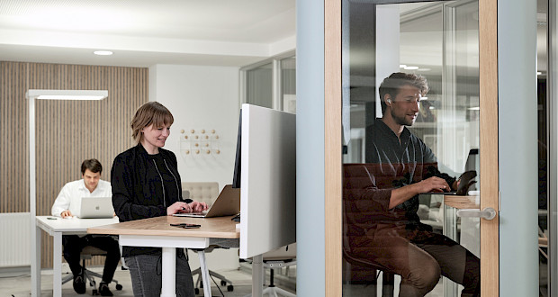 Height-adjustable desks and soundproof phone booths at Grünhof Augustinerplatz coworking space