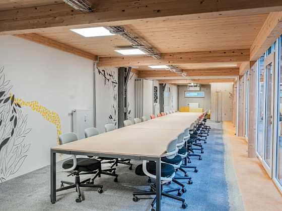 Großer Raum mit langer Tafel und vielen Stühlen