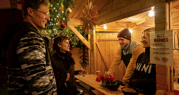 Leckere Speisen und Getränke in urigen Weihnachtsmarkt-Hütten