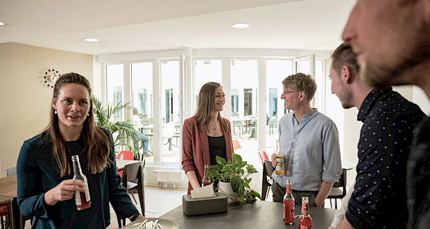 Coworking community chatting in the kitchen and exchanging ideas