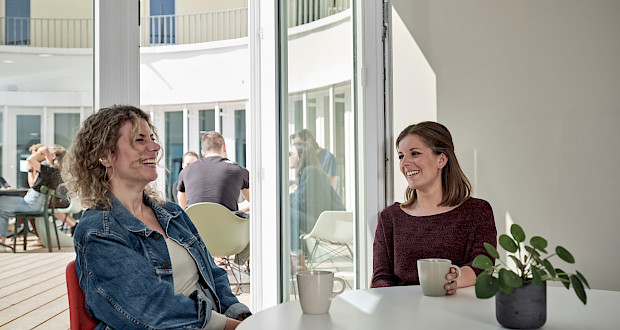 Coworkerinnen unterhalten sich in der KÜched